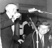 A person in a suit speaking into a microphone

AI-generated content may be incorrect.